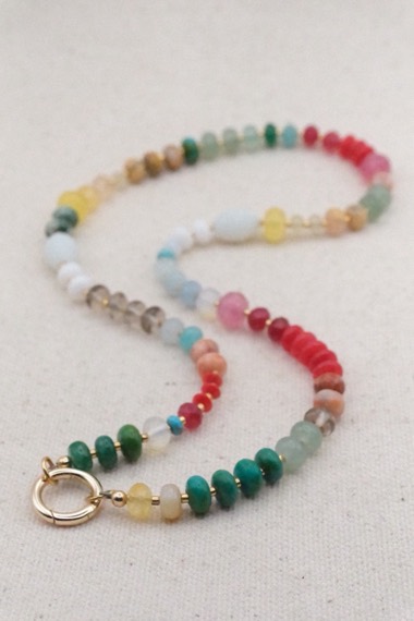 Rainbow gemstone strand with a gold clasp, on linen